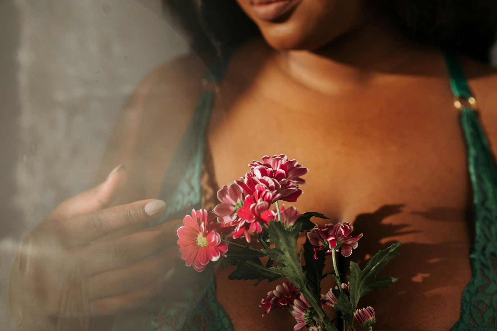Intimate portrait of a woman in lingerie holding vibrant flowers, evoking beauty and elegance.